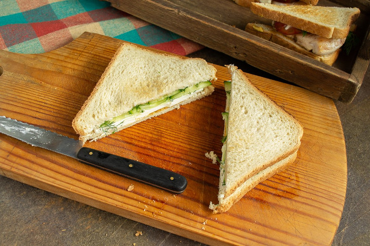 Накрываем сэндвич вторым тостом, смазанным сыром, и разрезаем