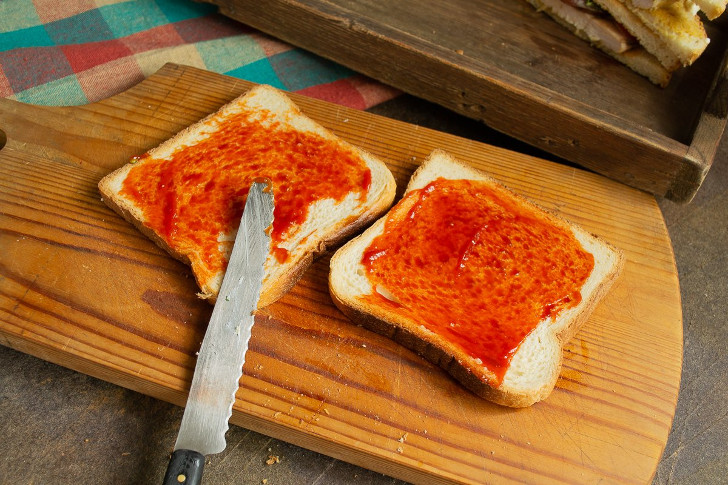 Для сэндвича с мясом и капустой смазываем поджаренные тосты кетчупом