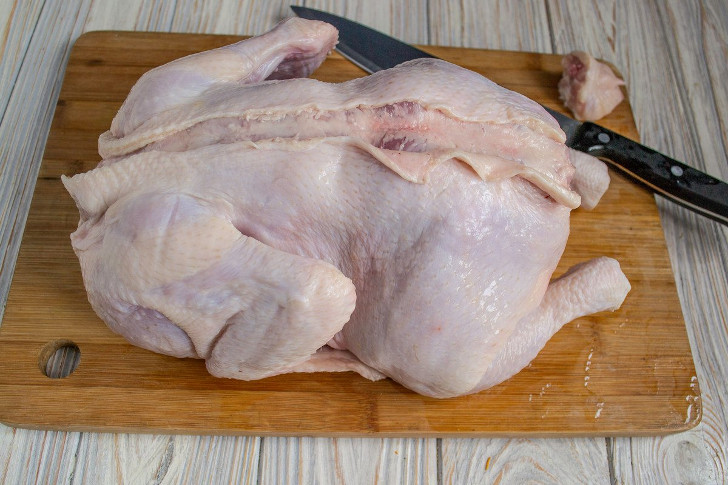 Разрезаем кожу цыплёнка вдоль спинки