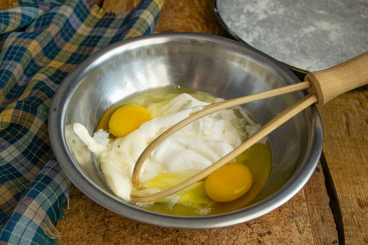 В миску разбиваем яйца, солим, добавляем майонез и сметану