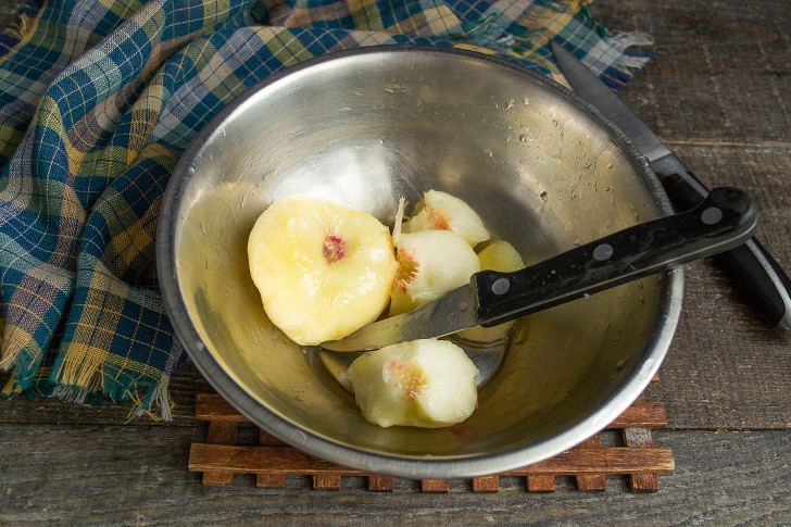 Перекладываем плоды в миску с ледяной водой, снимаем кожицу, разрезаем пополам и достаём косточки