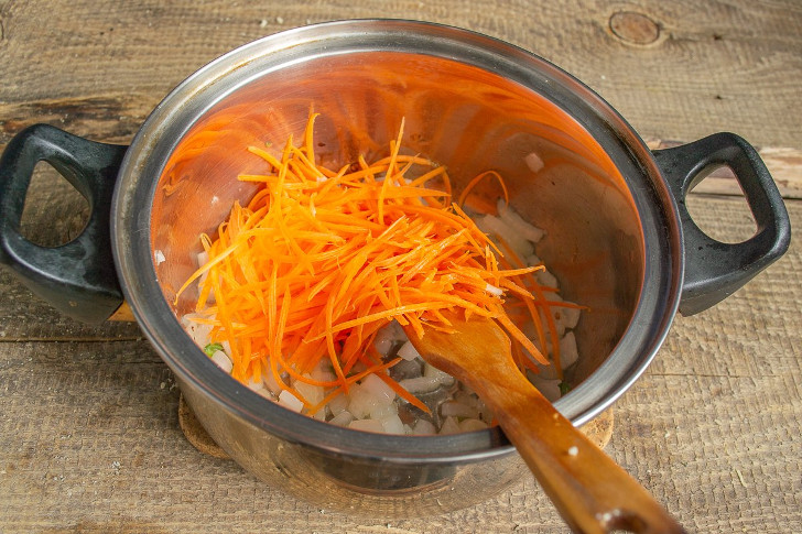 Добавляем морковные стружки, обжариваем овощи на умеренном огне