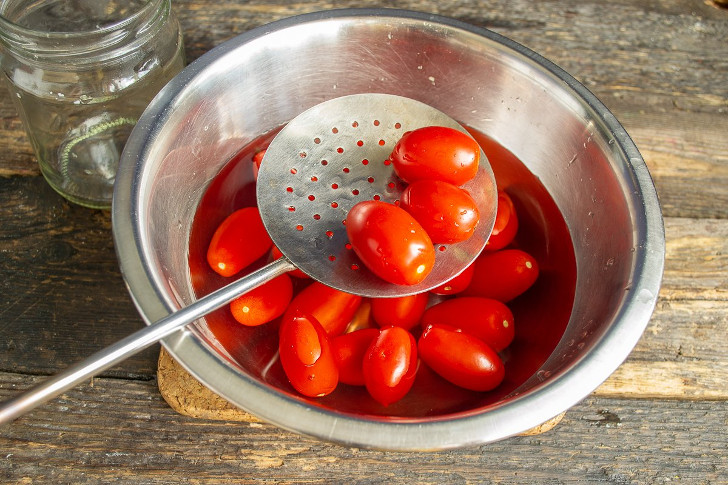 Кладём помидоры в кипящую воду на 1-2 минуты, перекладываем в подготовленную тару