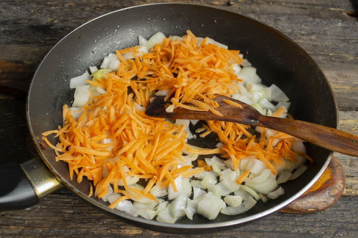 Добавляем тёртую морковь к луку, обжариваем несколько минут