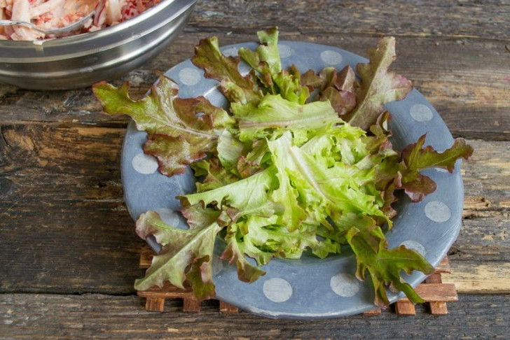 На дно тарелки кладём листочки салата