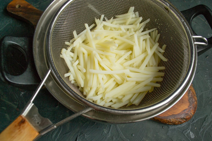 В кипящую воду кладём картофель, варим 2 минуты, сразу откидываем на сито