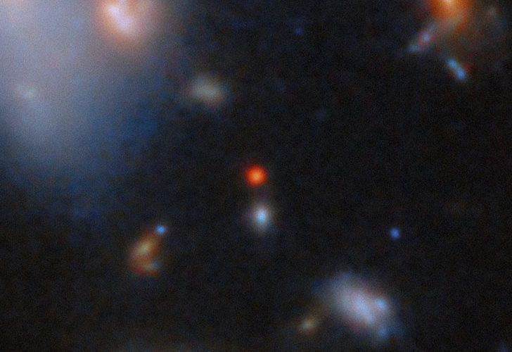 Галактика CANUCS-LRD-z8.6 видна яркой красной точкой в центре снимка. Credit: ESA, NASA, CSA